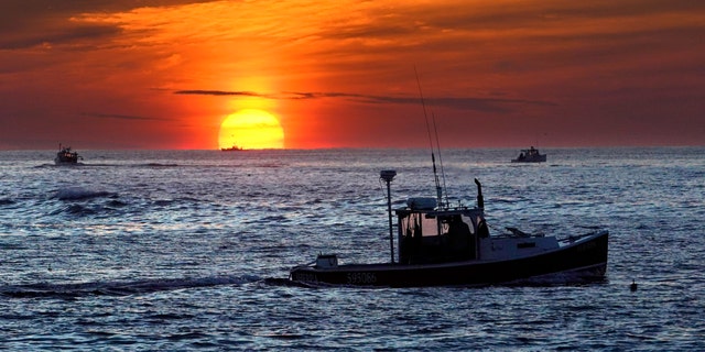 Lobster fishermen work at sunrise on Sept. 8, 2022, off Kennebunkport, Maine. The waters off New England logged the second-warmest temperatures in a year in recorded history in 2022.