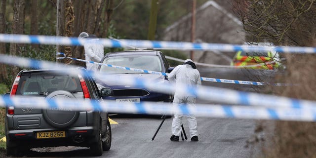 A forensic investigator from Police Service of Northern Ireland (PSNI) takes photos near to the sports complex in the Killyclogher Road area of Omagh, Co Tyrone, Northern Ireland, on Feb. 23, 2023 where off-duty PSNI Detective Chief Inspector John Caldwell was shot.