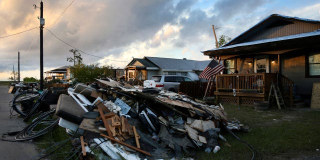 Debris and electrical wires are piled up in a front yard in Chauvin, Louisiana, after the hurricane on Sept. 27, 2021.