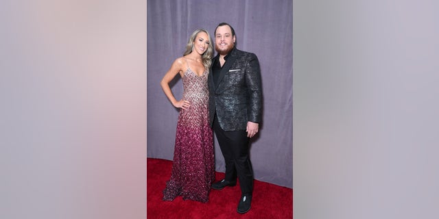 Luke Combs and wife Nicole Hocking smile while walking the red carpet at the Grammys.