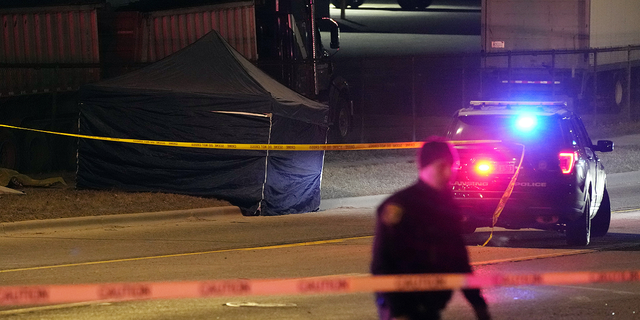 A tent covers the body of the alleged gunman on Tuesday, Feb. 14, in Lansing, Michigan, who opened fire Monday night at Michigan State University, killing three people and wounding five before fatally shooting himself.