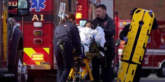 A patient is placed into an ambulance while being evacuated from Signature Healthcare Brockton Hospital, in Massachusetts, on Feb. 7, 2023, The hospital had to be partially evacuated after a fire broke out at its electrical transformer.