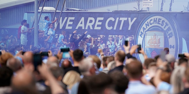 Los aficionados saludan a los jugadores del Manchester City antes del inicio del partido contra el Aston Villa en Manchester, Inglaterra, el domingo 22 de mayo de 2022.