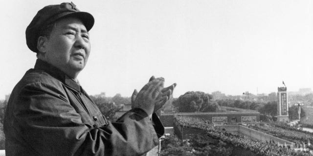 Mao Tse-Tung, chair of the Chinese Communist Party, on a balcony clapping his hands. 