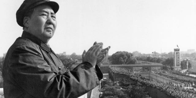 Mao Tse-Tung, chair of the Chinese Communist Party, on a balcony clapping his hands. 