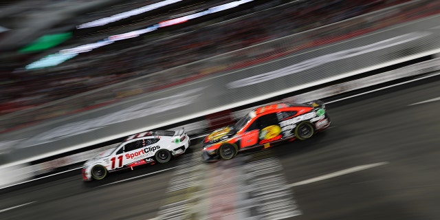 Denny Hamlin, driver of the #11 Sport Clips Haircuts Toyota, and Martin Truex Jr., driver of the #19 Bass Pro Shops Toyota, race during the NASCAR Clash at the Coliseum at Los Angeles Memorial Coliseum on February 05, 2023 in Los Angeles, California.