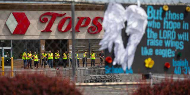 Investigators stand outside during a moment of silence for the victims of the Buffalo supermarket shooting outside a supermarket on May 21, 2022.