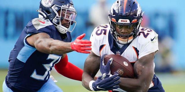 November 13, 2022;  Nashville, Tennessee, United States;  Denver Broncos running back Melvin Gordon III (25) is tackled by Tennessee Titans safety Kevin Byard (31) during the fourth quarter at Nissan Stadium.