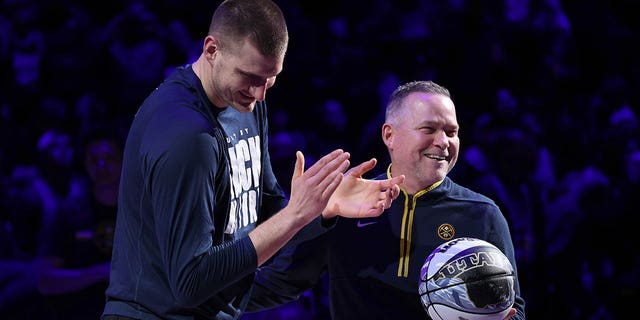 Nikola Jokic, #15, and Michael Malone of the Denver Nuggets are recognized for making the NBA All-Star Game during the game against the Dallas Mavericks at Ball Arena on February 15, 2023 in Denver.