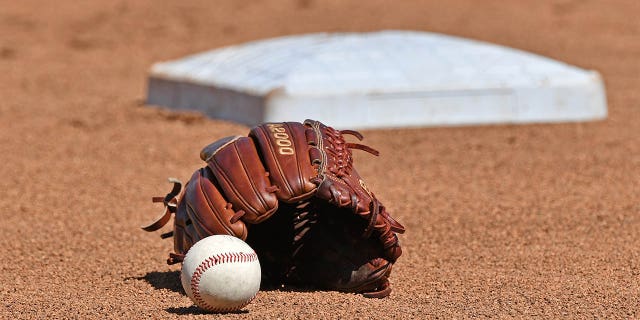 A baseball and glove on the field before Game 1 of the College World Series Championship Series between the Michigan Wolverines and the Vanderbilt Commodores on June 24, 2019 at TD Ameritrade Park Omaha in Omaha, Nebraska . 