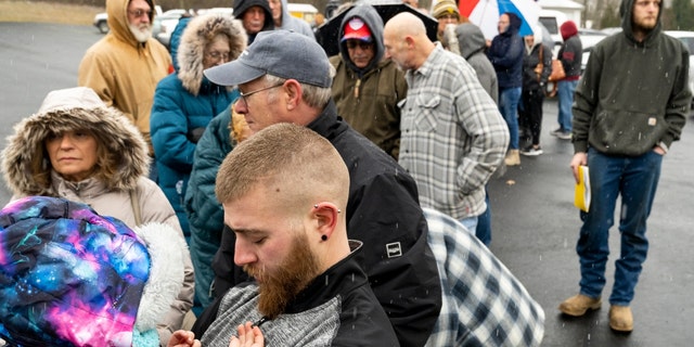 Neil Figley, 28, holds his daughter, Harlie, 4, wait in line at the Norfolk Southern Assistance Center to collect a $1,000 check and get reimbursed for expenses while they were evacuated following a train derailment prompting health concerns on Feb. 17, 2023, in East Palestine, Ohio. 