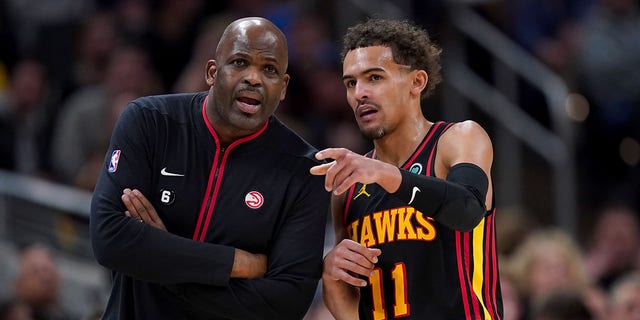 Atlanta Hawks head coach Nate McMillan meets with Trae Young (11) in the fourth quarter against the Indiana Pacers at Gainbridge Fieldhouse on January 13, 2023 in Indianapolis.