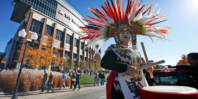 A woman plays a drum during a "No Honor in Racism Rally" in front of TCF Bank Stadium before a game between the Minnesota Vikings and the Kansas City Chiefs, on Oct. 18, 2015, in Minneapolis.