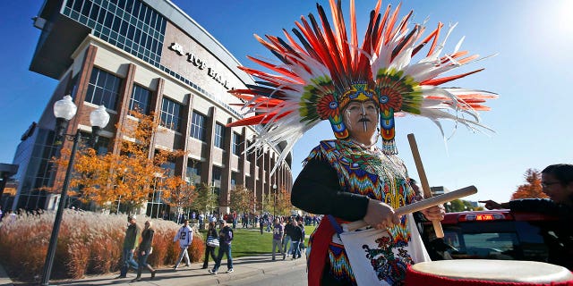 A woman plays a drum during a "No Honor in Racism Rally" in front of TCF Bank Stadium before a game between the Minnesota Vikings and the Kansas City Chiefs, on Oct. 18, 2015, in Minneapolis.
