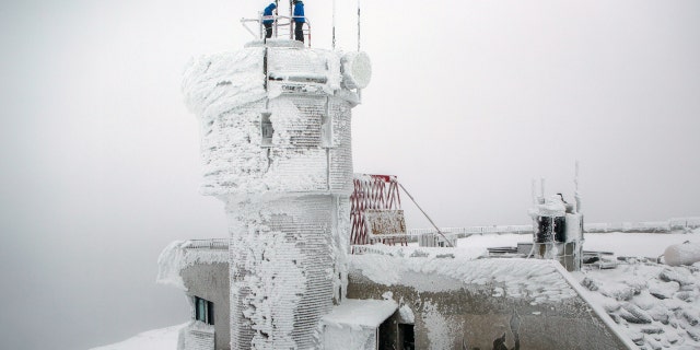 Mount Washington Observatory weather observers check on the weather instruments at the top of the observatory on the summit of Mount Washington.