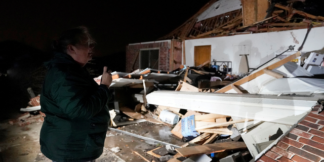 Extreme weather victim Barbara Buckner on Tuesday, Feb. 27, looked over her home that was destroyed by a tornado in Norman, Oklahoma.