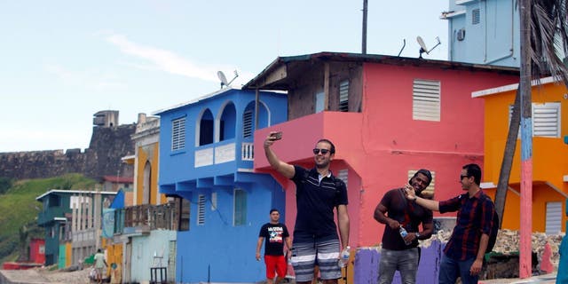 A man takes a selfie with his friends in the La Perla neighborhood, where the video "Despacito" was recorded in San Juan, on July 22, 2017.