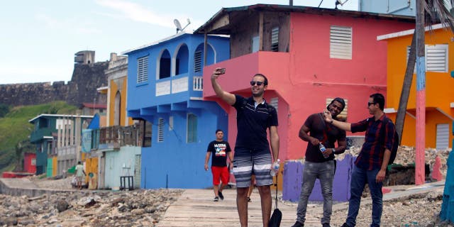 A man takes a selfie with his friends in the La Perla neighborhood, where the video "Despacito" was recorded in San Juan, on July 22, 2017.