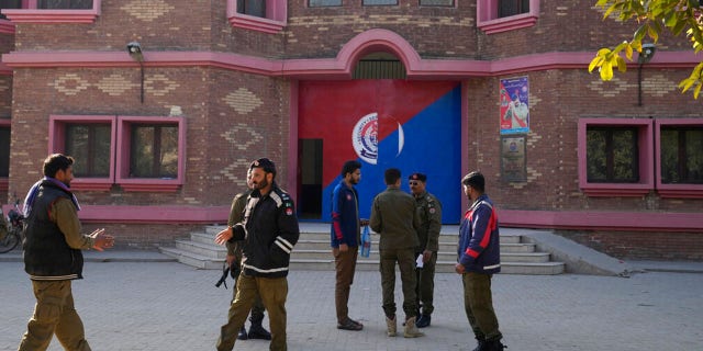 Police officers gather outside a police station, in Warburton, an area of district Nankana, Pakistan, Sunday, Feb. 12, 2023.