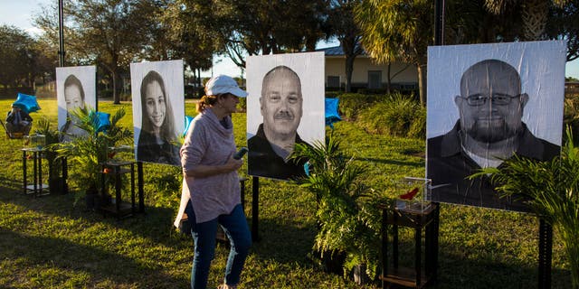 PARKLAND, FL - FEBRUARY 14: A woman visits a memorial with photos of the 17 people killed in the Marjory Stoneman Douglas High School mass shooting on the fifth anniversary at Pine Trails Park on February 14, 2023 in Parkland, Florida. On February 14, 2018, 14 students and three staff members were killed during a mass shooting at the school. (Photo by Saul Martinez/Getty Images)