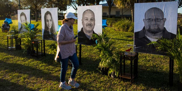 PARKLAND, FL - FEBRUARY 14: A woman visits a memorial with photos of the 17 people killed in the Marjory Stoneman Douglas High School mass shooting on the fifth anniversary at Pine Trails Park on February 14, 2023 in Parkland, Florida. On February 14, 2018, 14 students and three staff members were killed during a mass shooting at the school. (Photo by Saul Martinez/Getty Images)