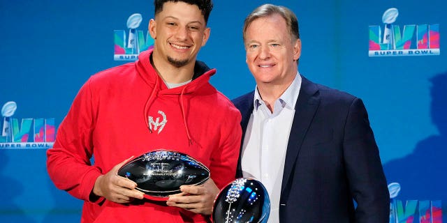 I-quarterback ye-Kansas City Chiefs u-Patrick Mahomes, kwesobunxele, uphethe i-Super Bowl MVP Trophy njengoba emi eduze kukaKhomishana we-NFL uRoger Goodell ngesikhathi kunengqungquthela yezindaba zebhola lezinyawo ye-NFL Super Bowl e-Phoenix, ngoMsombuluko, Feb. 13, 2023.