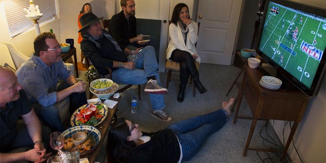 Group of people watch NFL Super bowl XLVIII on television, Feb. 2, Denver Broncos vs Seattle Seahawks. (Photo by: Joe Sohm/Visions of America/Universal Images Group via Getty Images)