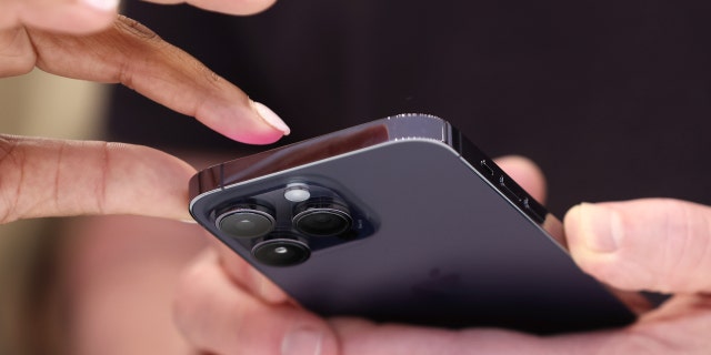  Attendees examine a brand new iPhone 14 Pro during an Apple special event on September 7, 2022, in Cupertino, California.