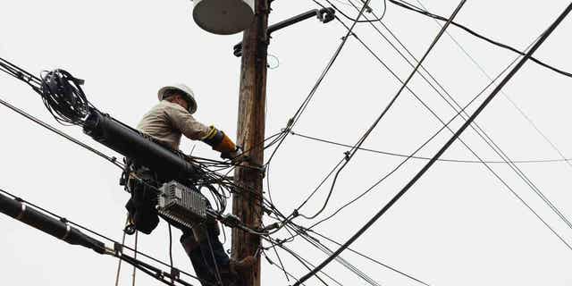 Ein Lineman arbeitet daran, die Stromversorgung in Nachbarschaften wiederherzustellen.  Über 170.000 Einwohner in Ohio sind ohne Strom, nachdem am Samstag, dem 25. März, starke Winde über den Mittleren Westen gezogen sind.