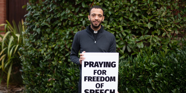 Father Sean Gough is his "pray for free speech" sign. 