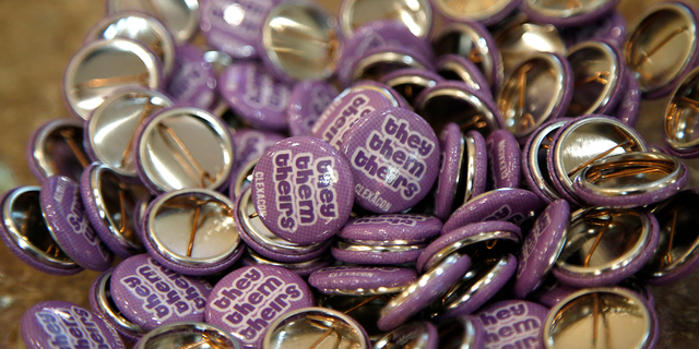 Buttons with the "they, them, theirs" pronouns are displayed during the ClexaCon 2021 convention at the Tropicana Las Vegas on October 09, 2021, in Las Vegas, Nevada. (Photo by Gabe Ginsberg/Getty Images)