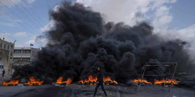 Palestinian protesters block the main road with burning tires in the West Bank city of Jericho, Monday, Feb. 6, 2023. Israeli forces killed five Palestinian gunmen in a raid on refugee camp in the occupied West Bank on Monday, the latest bloodshed in the region that will likely further exacerbate tensions. (AP Photo/Nasser Nasser)