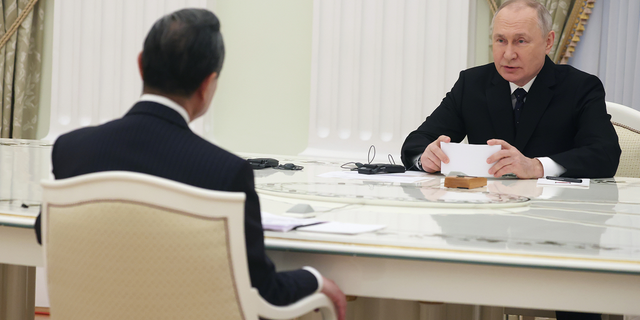 Russian President Vladimir Putin, right, speaks to the Chinese Communist Party's foreign policy chief Wang Yi during their meeting at the Kremlin on Feb. 22.