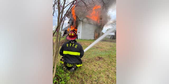 Paw Paw VFD Lt. Ethan Quillen is seen spraying water on a house fire.