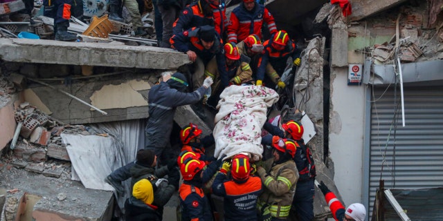 Turkish rescue workers carry Ergin Guzeloglan, 36, to an ambulance after pulled him out from a collapsed building five days after an earthquake in Hatay, southern Turkey, early Saturday, Feb. 11, 2023. 