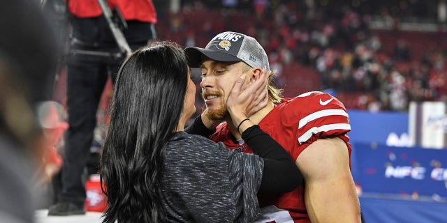 George Kittle de los San Francisco 49ers abraza a su esposa Claire después de ganar un partido contra los Green Bay Packers en el Levi's Stadium.