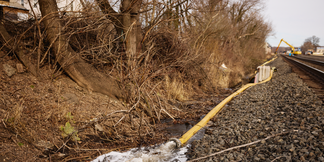 Water is rerouted near the site of a train derailment in East Palestine, Ohio, on Tuesday.