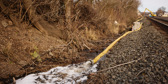 Water is rerouted near the site of a train derailment in East Palestine, Ohio, on Tuesday.