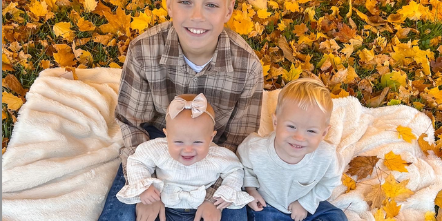 Little Harper Reese pinch her brothers, Lance (holding Harper) and Hudson.
