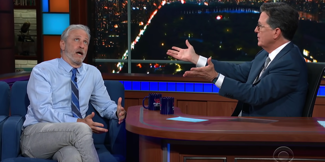 Jon Stewart, left, tells Stephen Colbert why he believes COVID-19 leaked from a lab in Wuhan, China, on "The Late Show" on June 14, 2021.