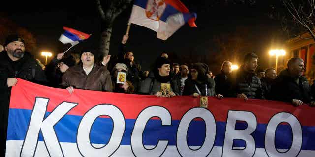 People hold a Serbian flag reading "Kosovo" during a protest against the Serbian authorities in Belgrade, Serbia, on Feb. 15, 2023. Five people were arrested for allegedly calling for the violent overthrow of the country's president.