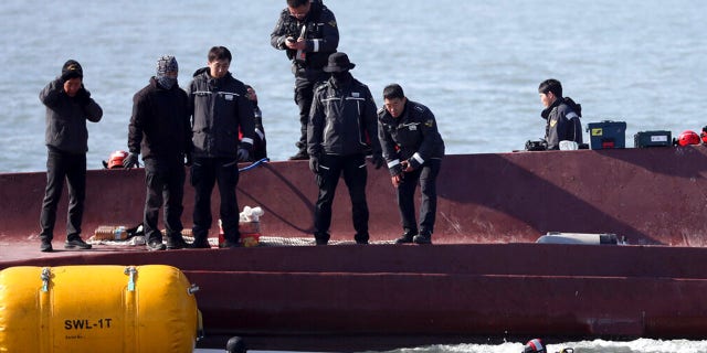 Members of a rescue team search for people from a capsized boat in waters off the country's southwestern coast, South Korea, Sunday, Feb. 5, 2023.