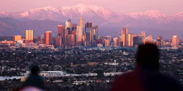 People look toward the downtown skyline of Los Angeles, California, on January 31, 2023. Strong winds and unusually cold air is heading toward Southern California.  
