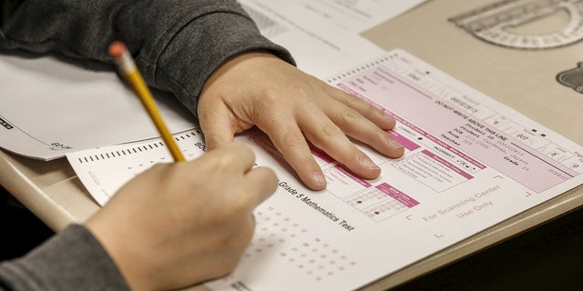 Hands of a student are shown with pencil and test booklet during New York State math test on May 2, 2017.
