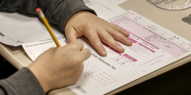 New York lowering minimum test scores for student proficiency in math , English: report 2 The hands of a student are shown with pencil and test booklet during a New York State math test on May 2, 2017. Math proficiency scores fell 8% last year when compared to pre-coronavirus figures, a report says.