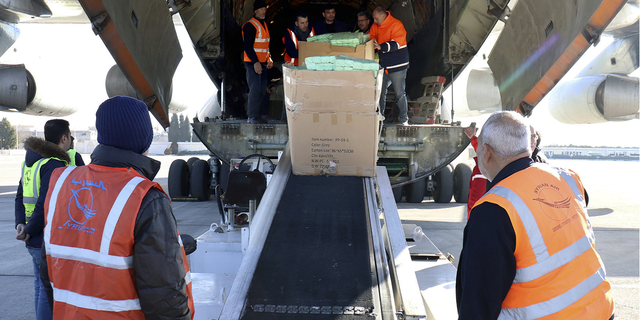 Workers unload humanitarian aid sent from Armenia, for Syria following a devastating earthquake, at the airport in Aleppo, Syria, on Thursday, Feb. 9.