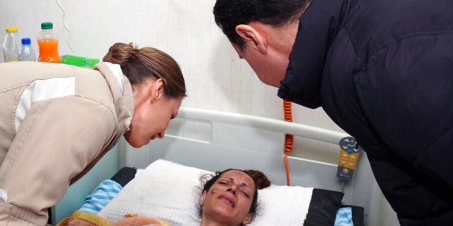In this photo released by the official Syrian state news agency SANA, Syrian President Bashar Assad, left, and his wife Asma, visit a wounded survivor of a devastating earthquake, at a hospital in the coastal city of Latakia, Syria, Saturday, Feb. 11, 2023.
