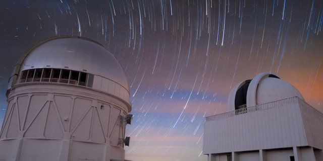 تُظهر صورة التعريض الطويل هذه حركة النجوم ليلاً فوق تلسكوب بلانكو البالغ ارتفاعه 4 أمتار (يسار) وتلسكوب SMARTS بطول 1.5 متر (يمين) في مرصد Cerro Tololo Inter-American في تشيلي ، وهو برنامج تابع لمؤسسة NSF الوطنية للأشعة تحت الحمراء البصرية. معمل البحوث الفلكية.