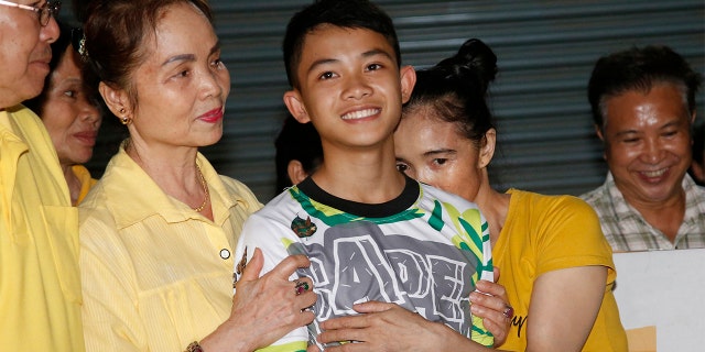 Relatives of Duangphet "Dom" Phromthep, one of the boys rescued from the flooded cave in northern Thailand, greet him as he arrives home in the Mae Sai district, Chiang Rai province, northern Thailand, on July 18, 2018. 