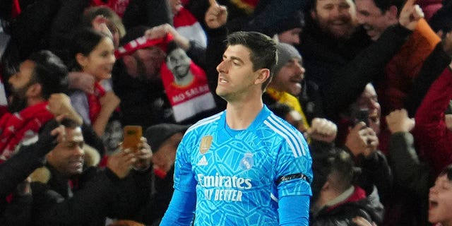 Real Madrid's goalkeeper Thibaut Courtois, right, gestures after Liverpool's Mohamed Salah scores his side's second goal during the Champions League, round of 16, first leg soccer match between Liverpool and Real Madrid at the Anfield stadium in Liverpool, England, Tuesday, Feb. 21, 2023.